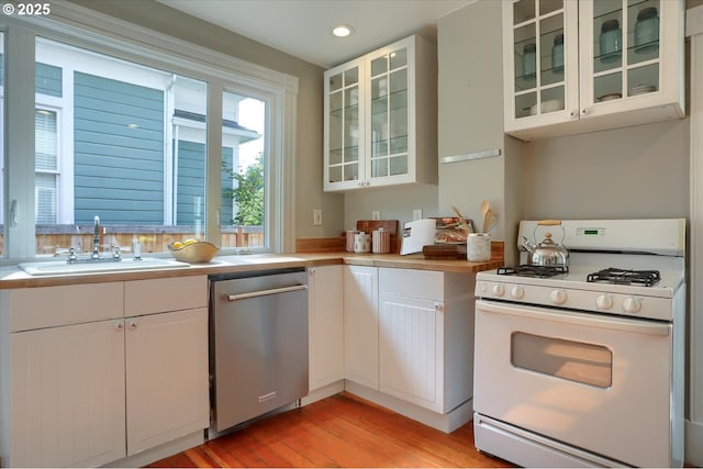 3324 SE Salmon St, Portland, OR 97214 - kitchen with white gas stove, dishwasher, light countertops, white cabinets, and light wood finished floors