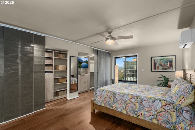 bedroom featuring ceiling fan, a wall mounted AC, hardwood / wood-style floors, and access to exterior