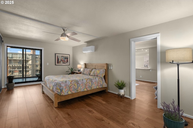 bedroom featuring ceiling fan, access to outside, hardwood / wood-style floors, and an AC wall unit