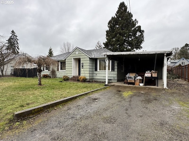 single story home featuring entry steps, driveway, a front yard, and fence