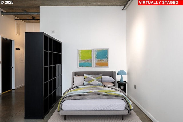 bedroom with baseboards and a towering ceiling