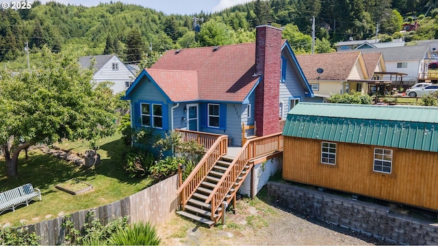 2720 Bowman Rd, Reedsport, OR 97467 - rear view of house with a deck, stairway, a forest view, and a chimney