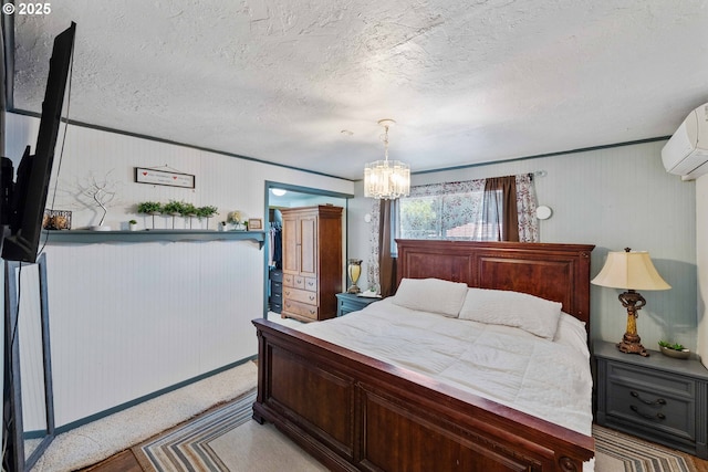 2720 Bowman Rd, Reedsport, OR 97467 - bedroom with a chandelier, an AC wall unit, a textured ceiling, baseboards, and wood walls