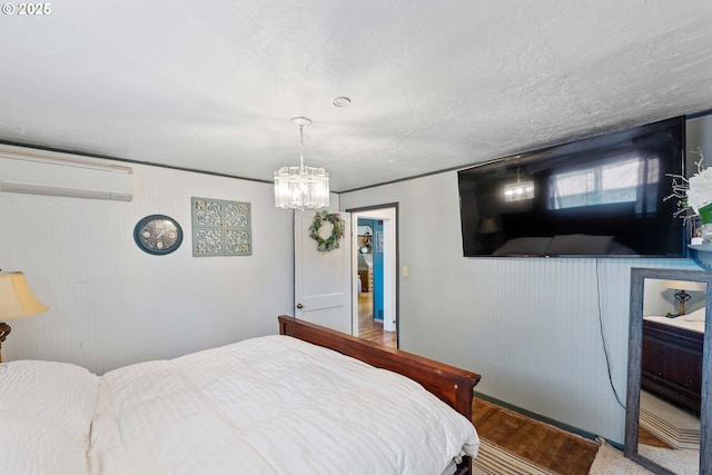 2720 Bowman Rd, Reedsport, OR 97467 - bedroom featuring a wall mounted AC, a chandelier, and wood finished floors