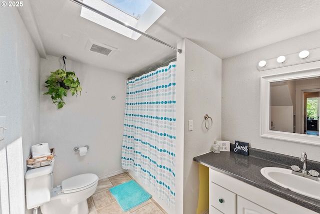 2720 Bowman Rd, Reedsport, OR 97467 - full bath with vanity, toilet, a skylight, tile patterned floors, and a shower with shower curtain