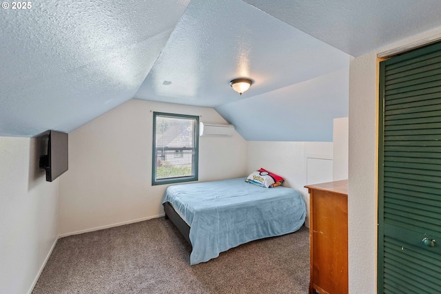 2720 Bowman Rd, Reedsport, OR 97467 - bedroom with a wall mounted AC, carpet, vaulted ceiling, baseboards, and a textured ceiling