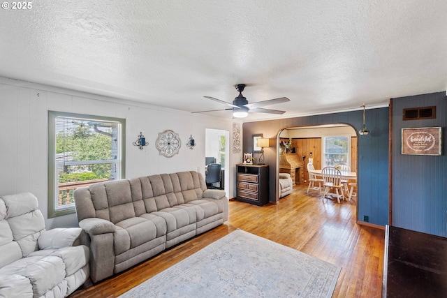 2720 Bowman Rd, Reedsport, OR 97467 - living room with arched walkways, a textured ceiling, plenty of natural light, and light wood-style flooring