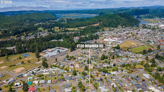 2720 Bowman Rd, Reedsport, OR 97467 - aerial view of residential area featuring a forest and a mountain backdrop