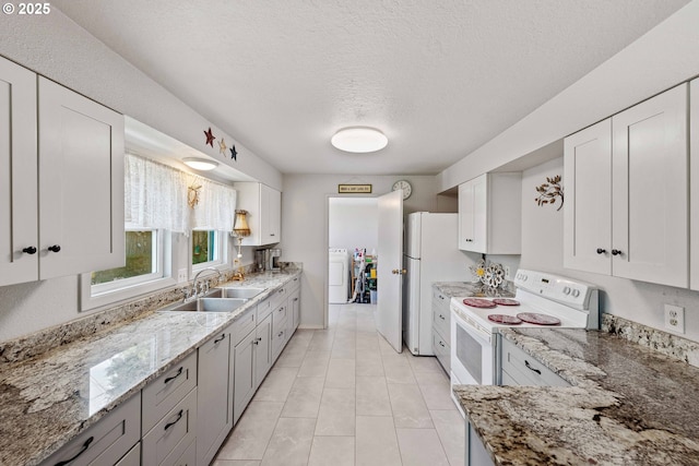 2720 Bowman Rd, Reedsport, OR 97467 - kitchen with a sink, washer / clothes dryer, white appliances, light stone counters, and a textured ceiling