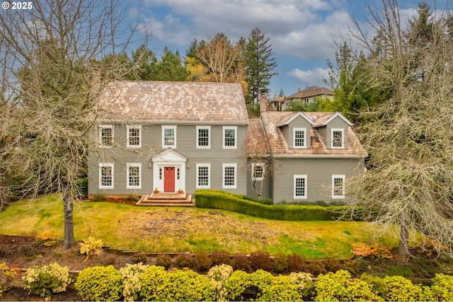 view of front of home featuring a front lawn and a chimney