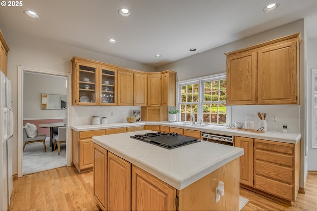 kitchen featuring a center island, light wood-type flooring, recessed lighting, black gas stovetop, and a sink