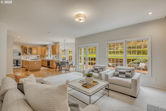 living room featuring beverage cooler, baseboards, recessed lighting, light wood-type flooring, and a chandelier