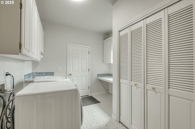 laundry room with cabinet space, baseboards, independent washer and dryer, and light floors