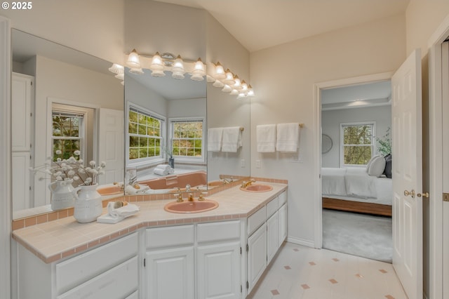 bathroom featuring a sink, connected bathroom, and a wealth of natural light