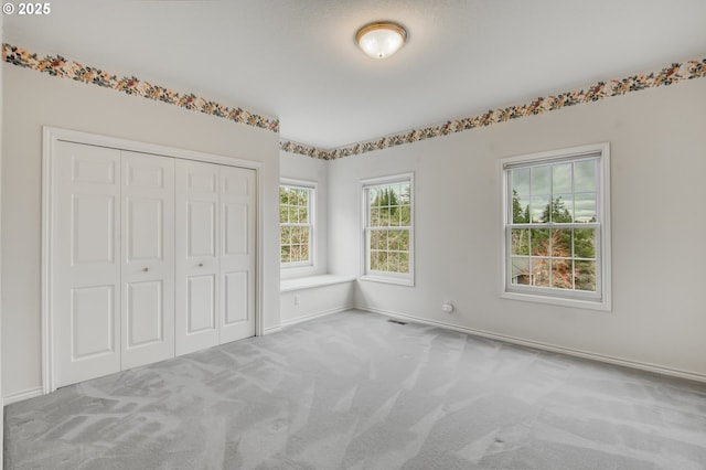 unfurnished bedroom with a closet, baseboards, and carpet