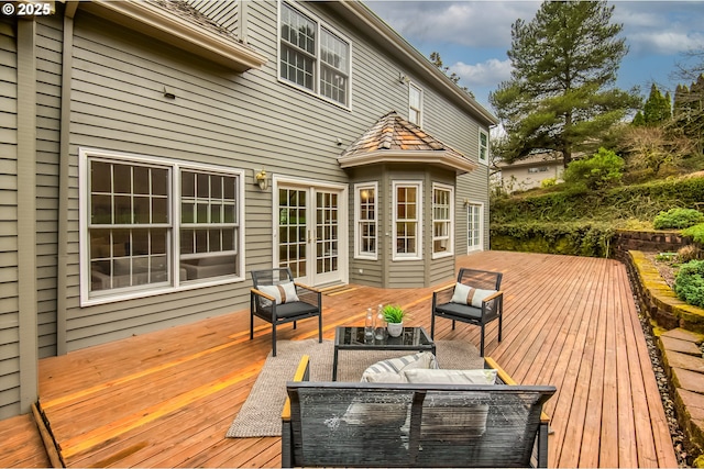 wooden deck with an outdoor living space and french doors