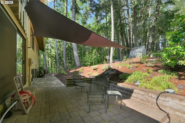 768 Brookside Dr, Eugene, OR 97405 - view of patio featuring a greenhouse, outdoor dining space, and an outdoor structure