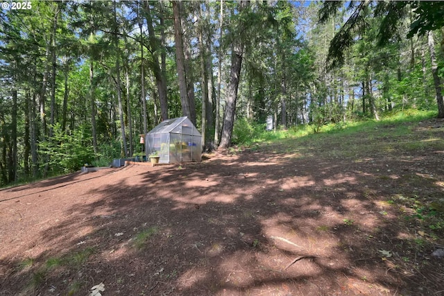 768 Brookside Dr, Eugene, OR 97405 - view of yard with a greenhouse, an outbuilding, and a view of trees