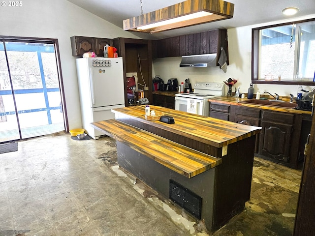 kitchen featuring dark brown cabinetry, butcher block counters, sink, vaulted ceiling, and white appliances