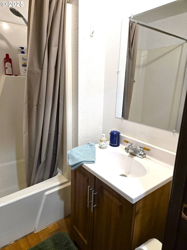 bathroom with vanity, hardwood / wood-style floors, and shower / bath combo with shower curtain