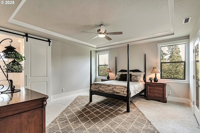 4909 NE 132nd Cir, Vancouver, WA 98686 - bedroom featuring a raised ceiling, carpet, a barn door, a textured ceiling, and baseboards