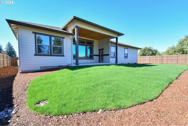 back of property featuring a fenced backyard and a lawn