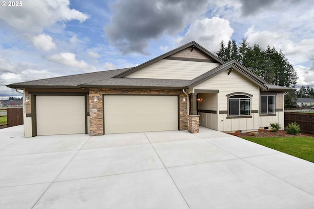 4909 NE 132nd Cir, Vancouver, WA 98686 - view of front facade with driveway, a garage, fence, roof with shingles, and stone siding