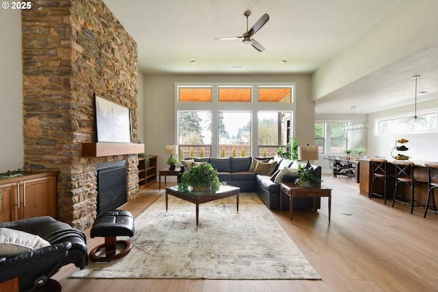4909 NE 132nd Cir, Vancouver, WA 98686 - living area with light wood finished floors, a textured ceiling, ceiling fan, and a fireplace