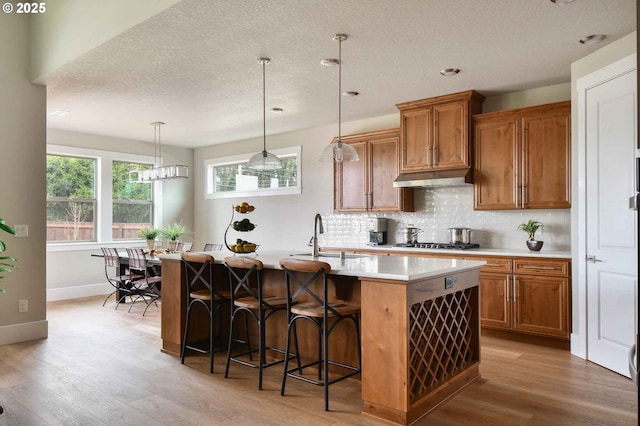 4909 NE 132nd Cir, Vancouver, WA 98686 - kitchen featuring a sink, brown cabinetry, light wood-style floors, light countertops, and a textured ceiling