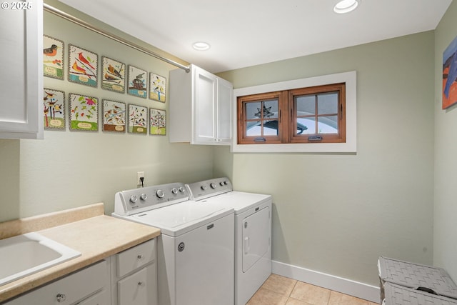 clothes washing area with light tile patterned floors, sink, cabinets, and washing machine and clothes dryer