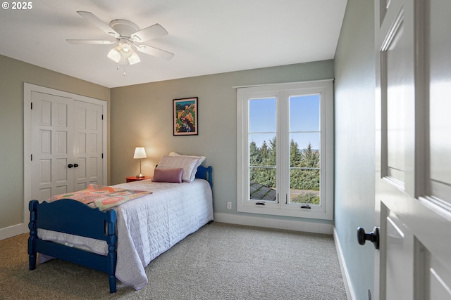 bedroom featuring light colored carpet, ceiling fan, and a closet