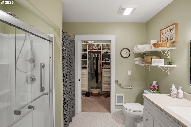 bathroom with a shower with door, vanity, and toilet