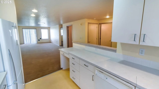 kitchen featuring white cabinetry, light colored carpet, and white appliances