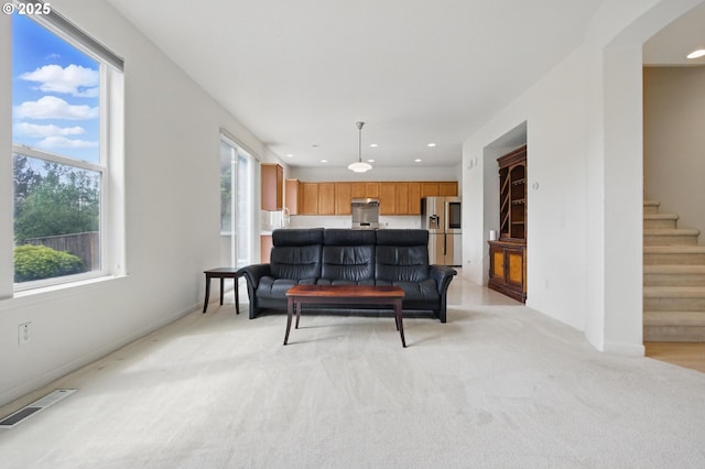 living room with visible vents, light carpet, baseboards, stairway, and recessed lighting
