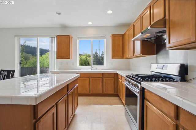 15820 SW Towhee Ln, Beaverton, OR 97007 - kitchen with range hood, stainless steel gas stove, tile countertops, a sink, and recessed lighting