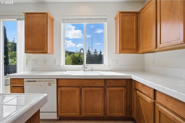 kitchen featuring a sink, white dishwasher, and brown cabinetry
