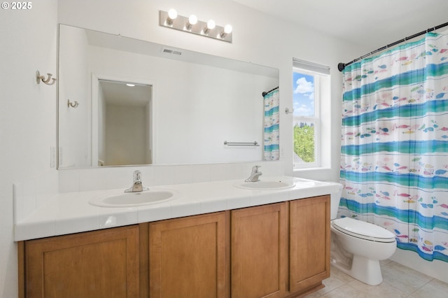 bathroom with a sink, toilet, double vanity, and visible vents