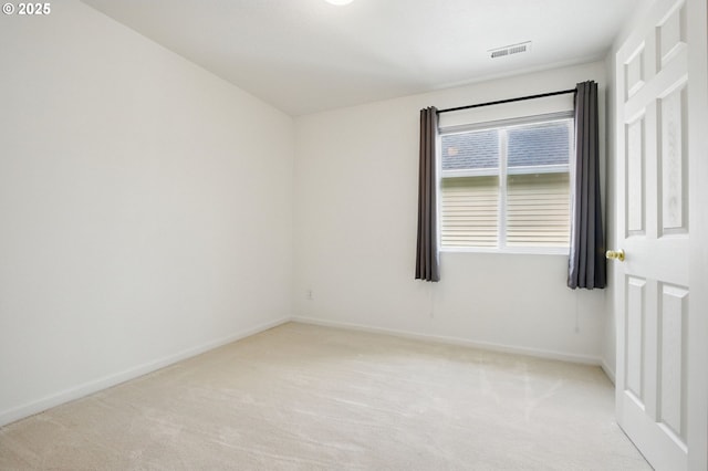 spare room featuring baseboards, light carpet, and visible vents