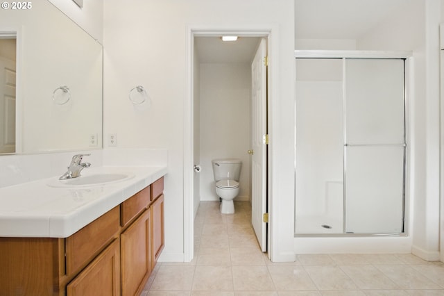 bathroom with vanity, toilet, tile patterned floors, and a stall shower