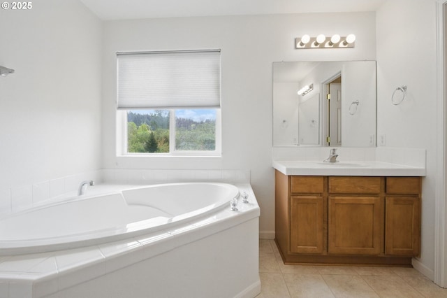 full bath featuring tile patterned floors, baseboards, vanity, and a garden tub
