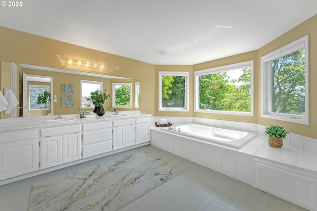 full bath with double vanity, tile patterned floors, and a bath