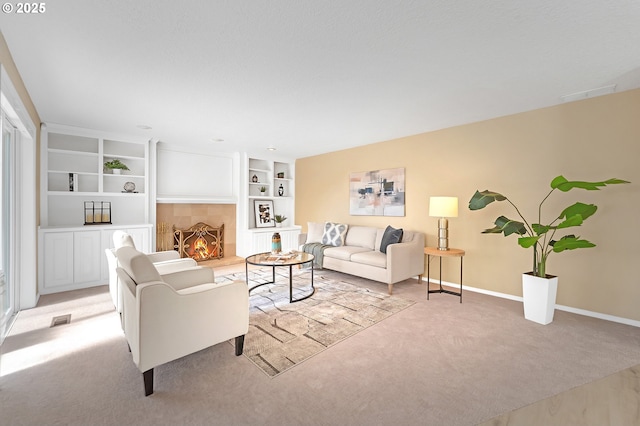 living room featuring light carpet, baseboards, built in features, and a fireplace