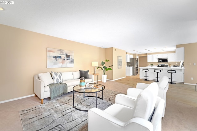 living room featuring light colored carpet and baseboards