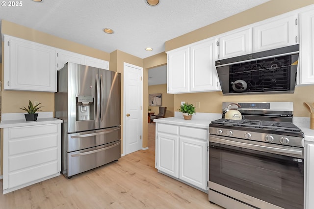 kitchen with stainless steel appliances, light countertops, light wood finished floors, white cabinets, and recessed lighting