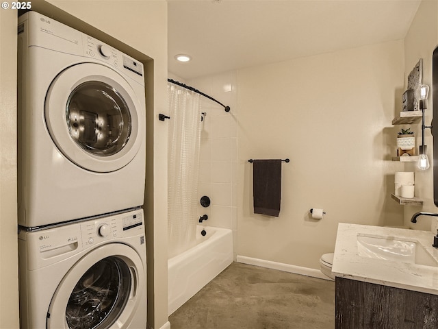 1030 NW 12th Ave Unit 410, Portland, OR 97209 - clothes washing area featuring baseboards, stacked washer / dryer, laundry area, and a sink
