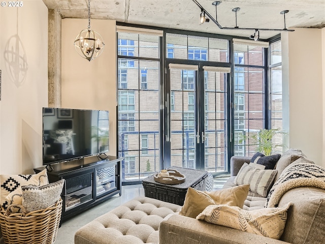 1030 NW 12th Ave Unit 410, Portland, OR 97209 - living room featuring track lighting, an inviting chandelier, expansive windows, and a wealth of natural light