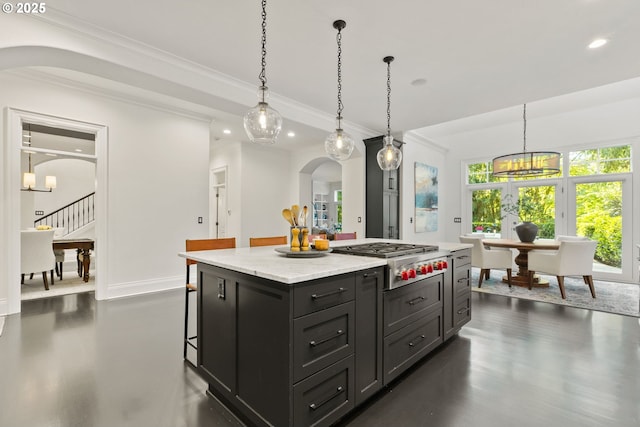 kitchen featuring arched walkways, stainless steel gas cooktop, recessed lighting, crown molding, and a center island