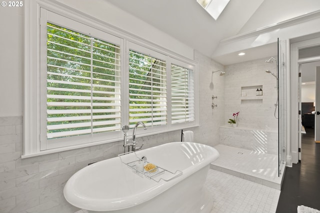 full bathroom featuring a tile shower, a freestanding bath, tile patterned floors, tile walls, and vaulted ceiling