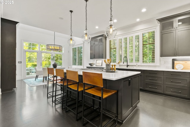 kitchen featuring a kitchen island, a sink, a breakfast bar area, recessed lighting, and glass insert cabinets