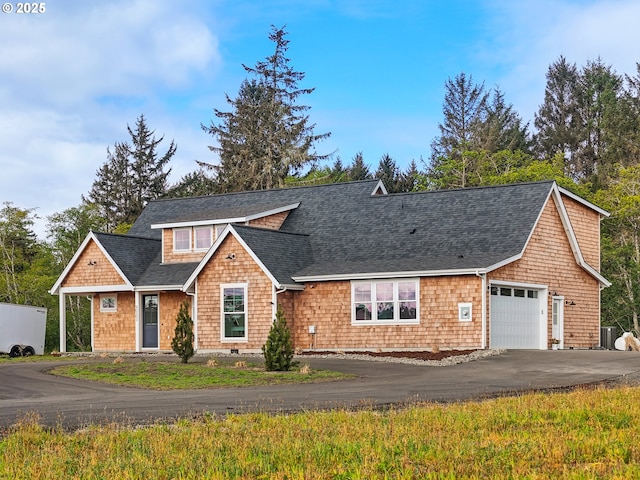 90202 Hobie Rd, Warrenton, OR 97146 - view of front of house with a shingled roof, driveway, a garage, and cooling unit